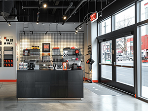 An image of a store with red and black merchandise displayed on shelves attached to black wire grid